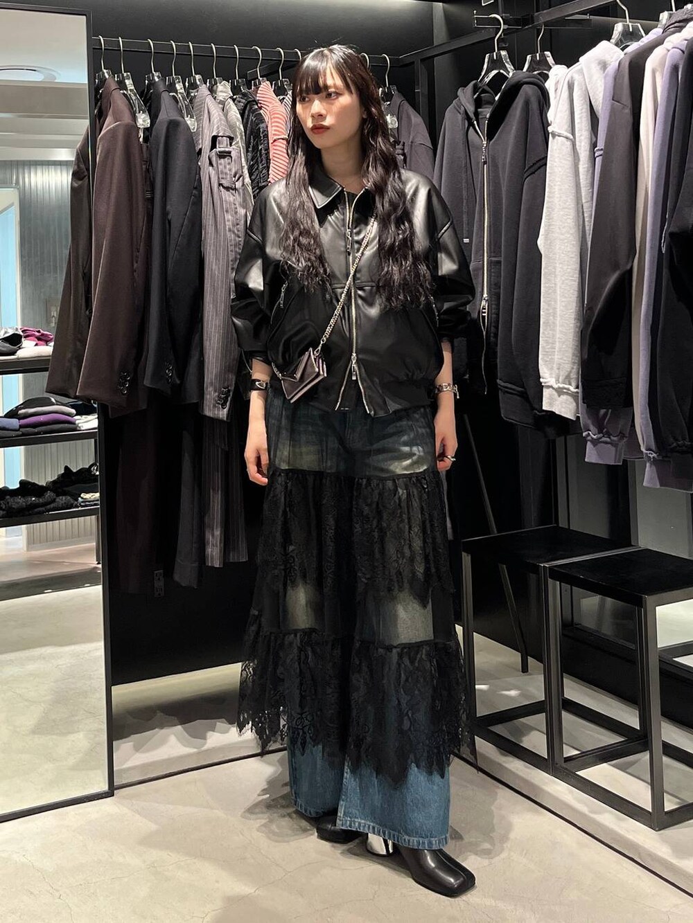 ブルー系のデニムパンツ、ブラック系のブーツ、ブラック系のブルゾンを着用したレディースの秋コーディネートの4枚目の写真