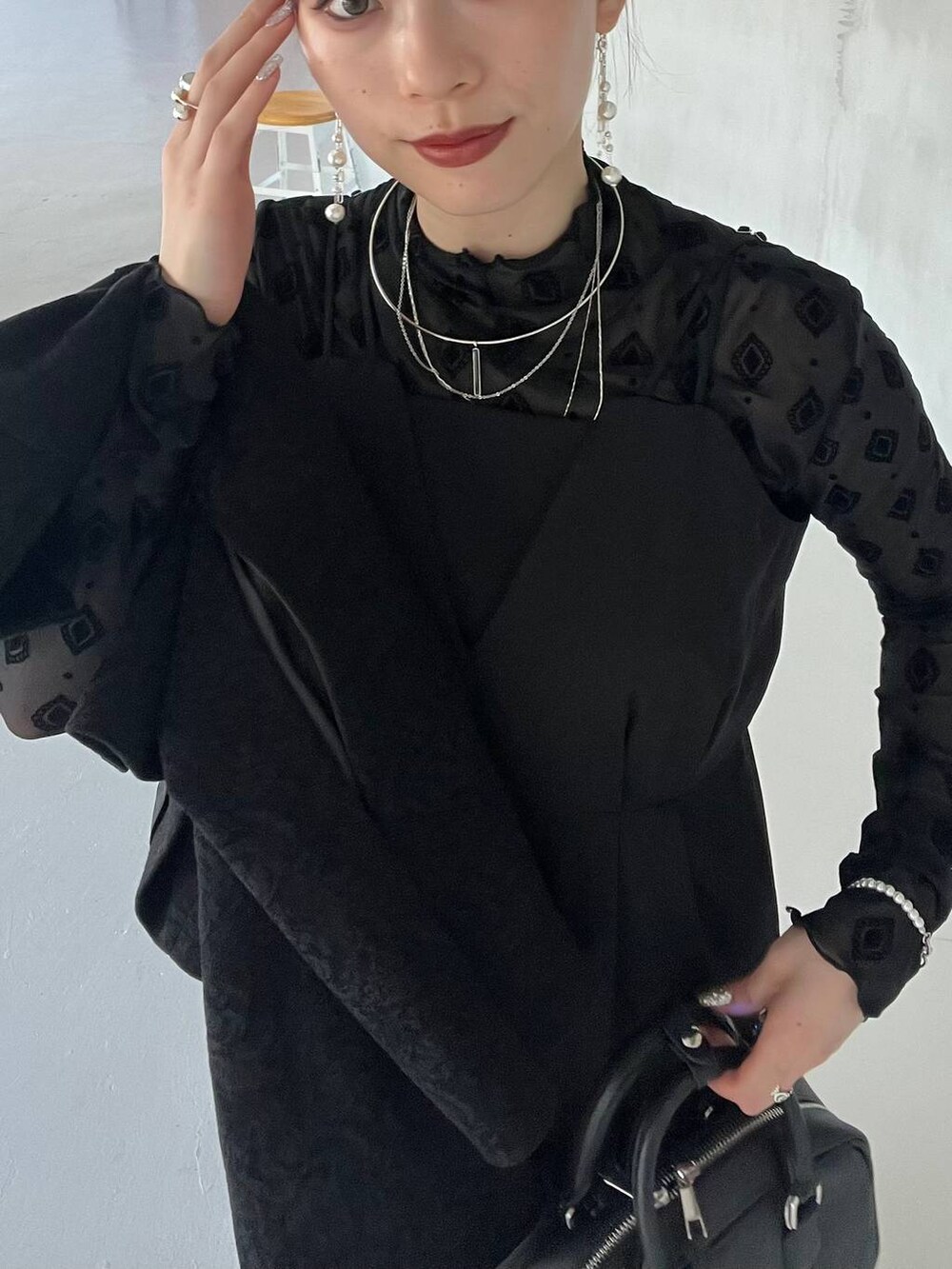 ブラック系のパンプス、ブラック系のボストンバッグ、ブラック系のテーラードジャケットを着用したレディースの夏コーディネートの2枚目の写真