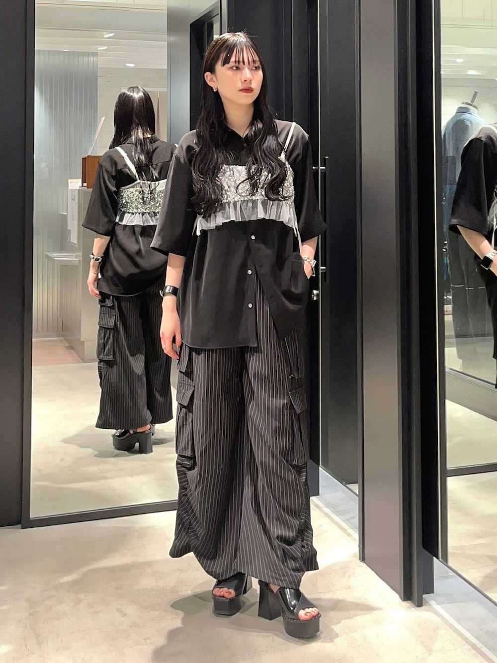 ブラック系のサンダル、シルバー系のチューブトップ、ブラック系のシャツ/ブラウスを着用したレディースの春コーディネートの2枚目の写真