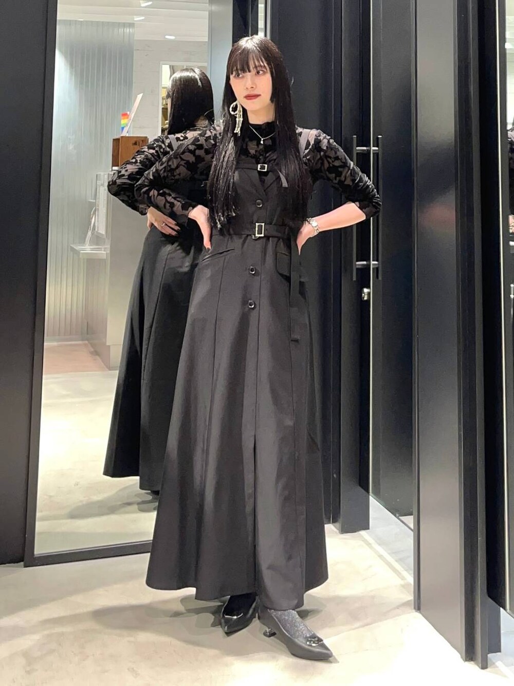 ブラック系のジャンパースカート、シルバー系のパンプス、シルバー系のピアス（両耳用）を着用したレディースの夏コーディネートの2枚目の写真