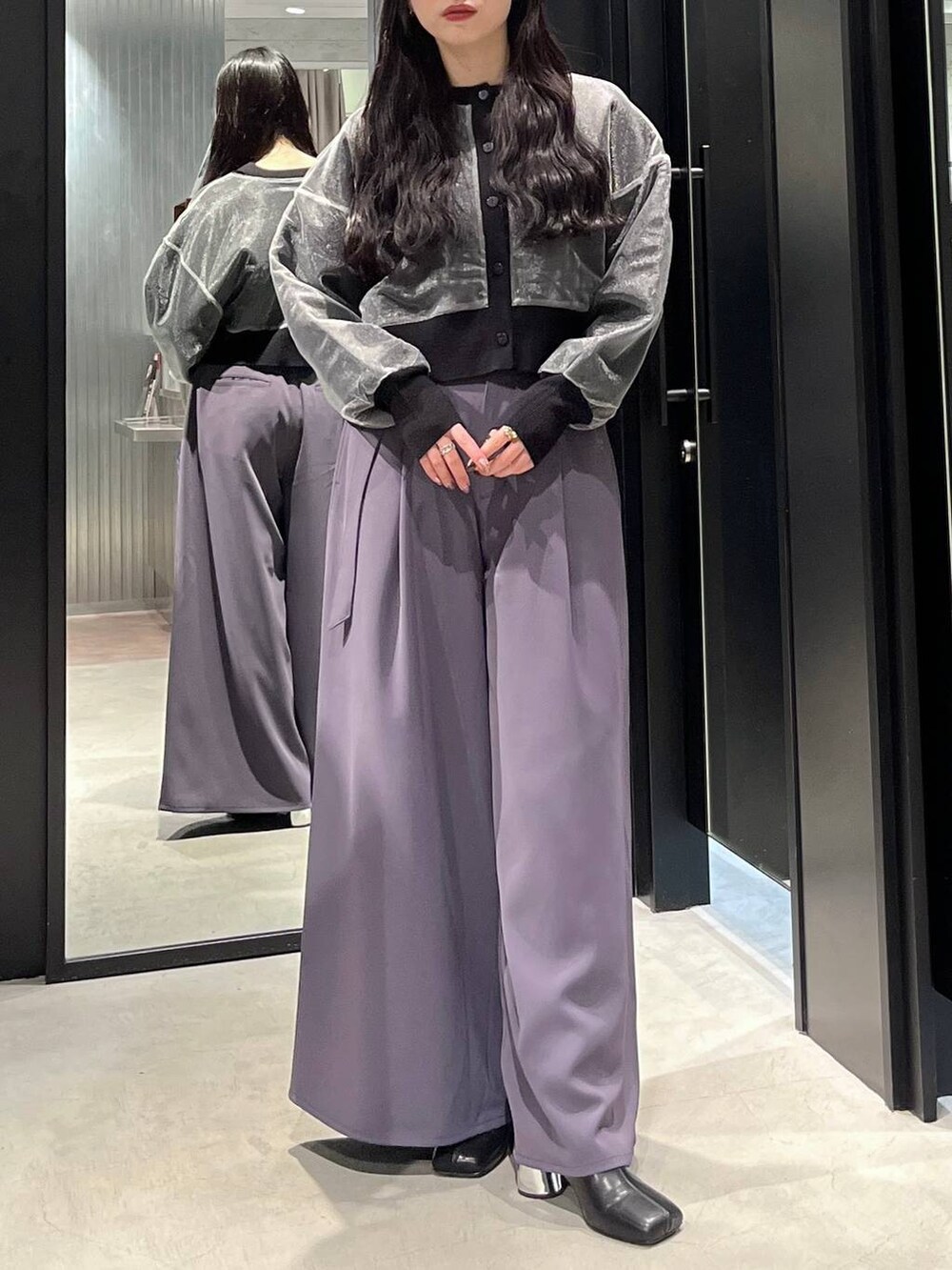 ブラック系のブーツ、パープル系のその他パンツ、ブラック系のカーディガン/ボレロを着用したレディースの冬コーディネートの3枚目の写真