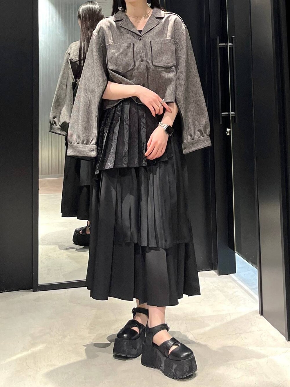 ブラック系のサンダル、ブラック系のスカート、ブラック系のシャツ/ブラウスを着用したレディースの春コーディネートの3枚目の写真