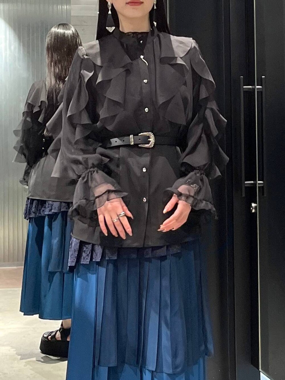 ブラック系のサンダル、ブラック系のシャツ/ブラウス、ブルー系のスカートを着用したレディースの春コーディネートの4枚目の写真