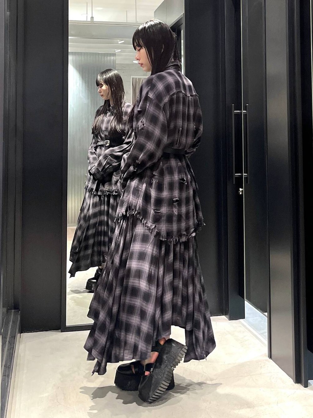 ブラック系のシャツ/ブラウス、ブラック系のサンダル、ブラック系のスカートを着用したレディースの春コーディネートの2枚目の写真