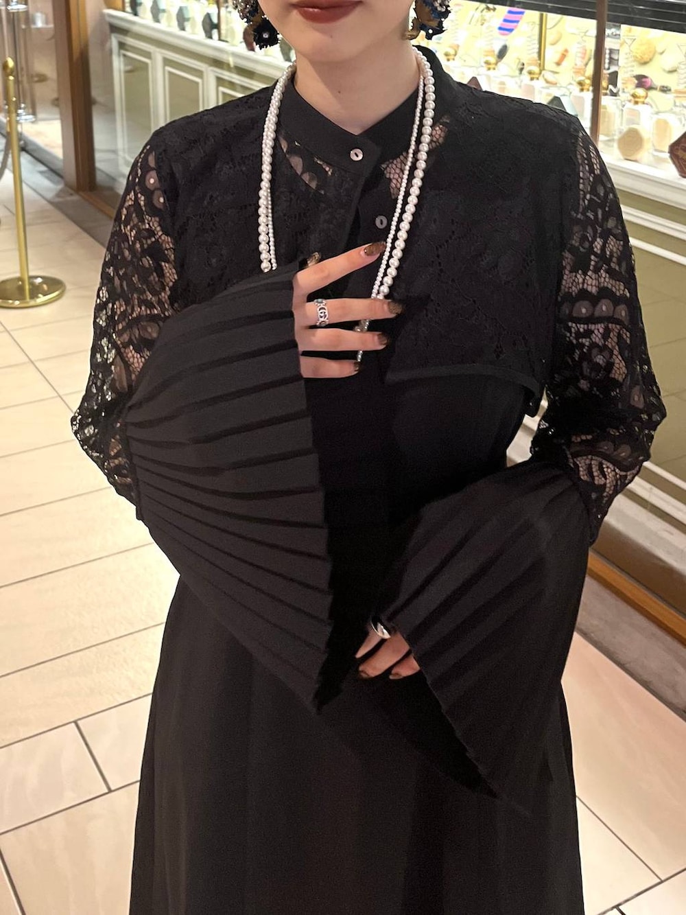 ブラック系のドレス、ゴールド系のネックレスを着用したレディースの夏コーディネートの5枚目の写真