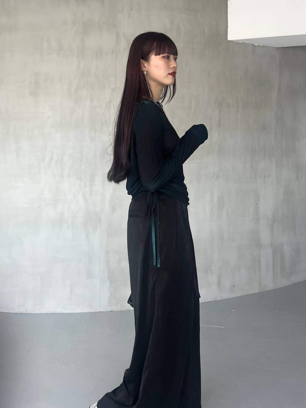 ブラック系のショルダーバッグ、ブラック系のその他パンツ、グリーン系のTシャツ/カットソーを着用したレディースの夏コーディネートの7枚目の写真