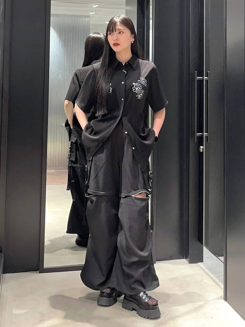 ブラック系のサンダル、ブラック系のカーゴパンツ、ブラック系のシャツ/ブラウスを着用したレディースの春コーディネートの2枚目の写真