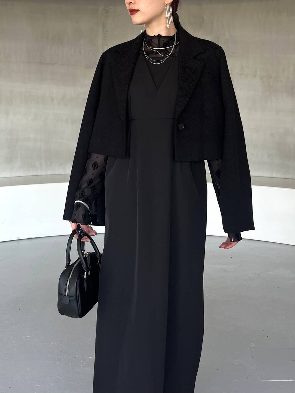 ブラック系のパンプス、ブラック系のボストンバッグ、ブラック系のテーラードジャケットを着用したレディースの夏コーディネートの6枚目の写真