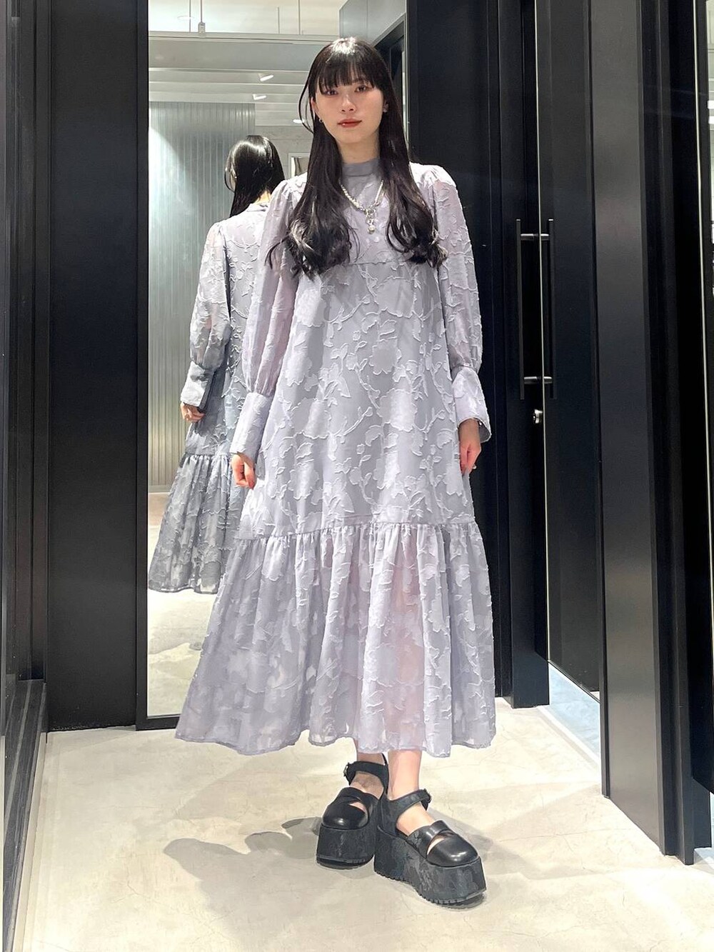 ブラック系のサンダル、グレー系のワンピース、ホワイト系のネックレスを着用したレディースの春コーディネートの2枚目の写真