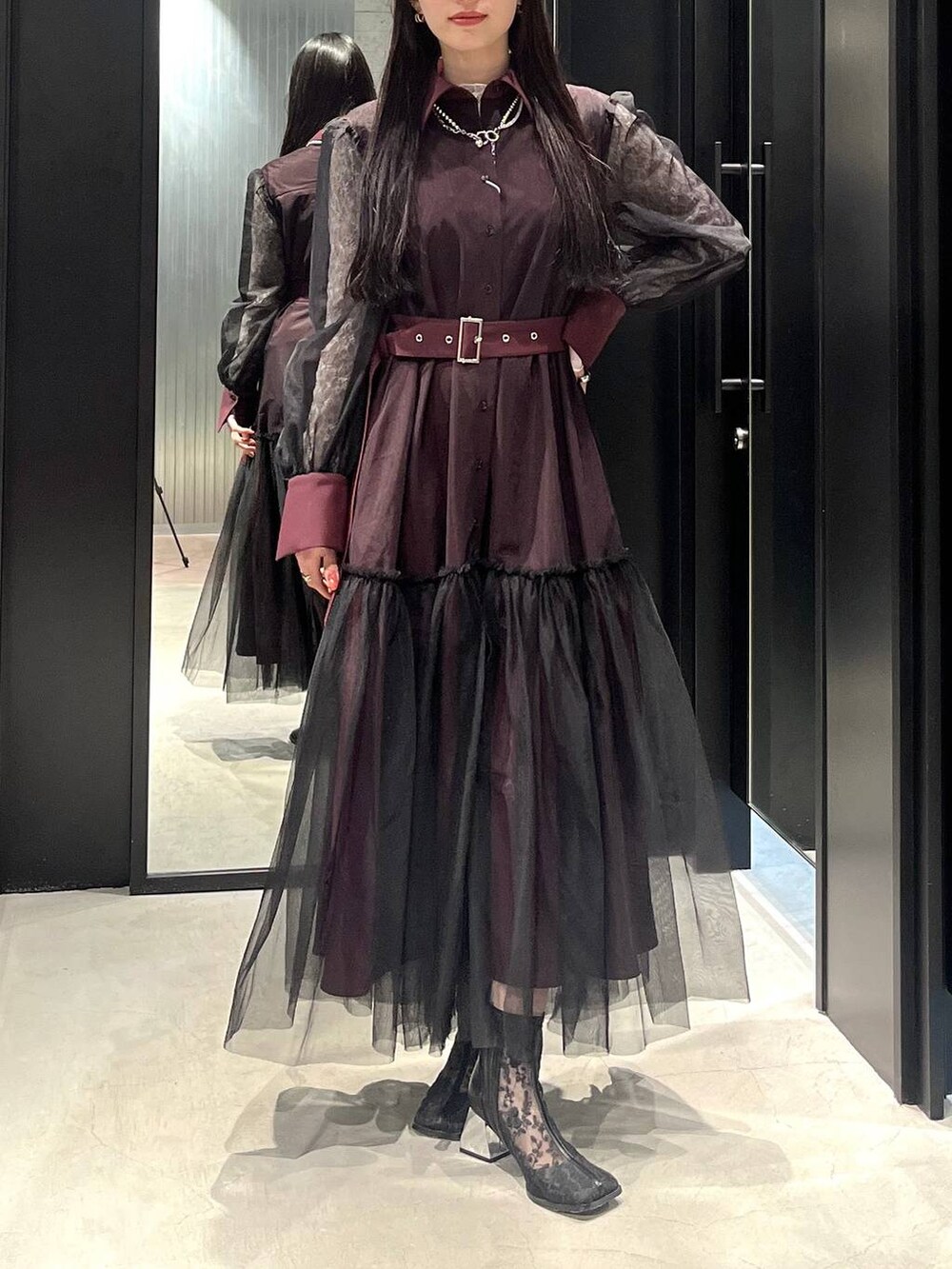 ブラック系のブーツ、レッド系のワンピース、シルバー系のネックレスを着用したレディースの春コーディネートの3枚目の写真