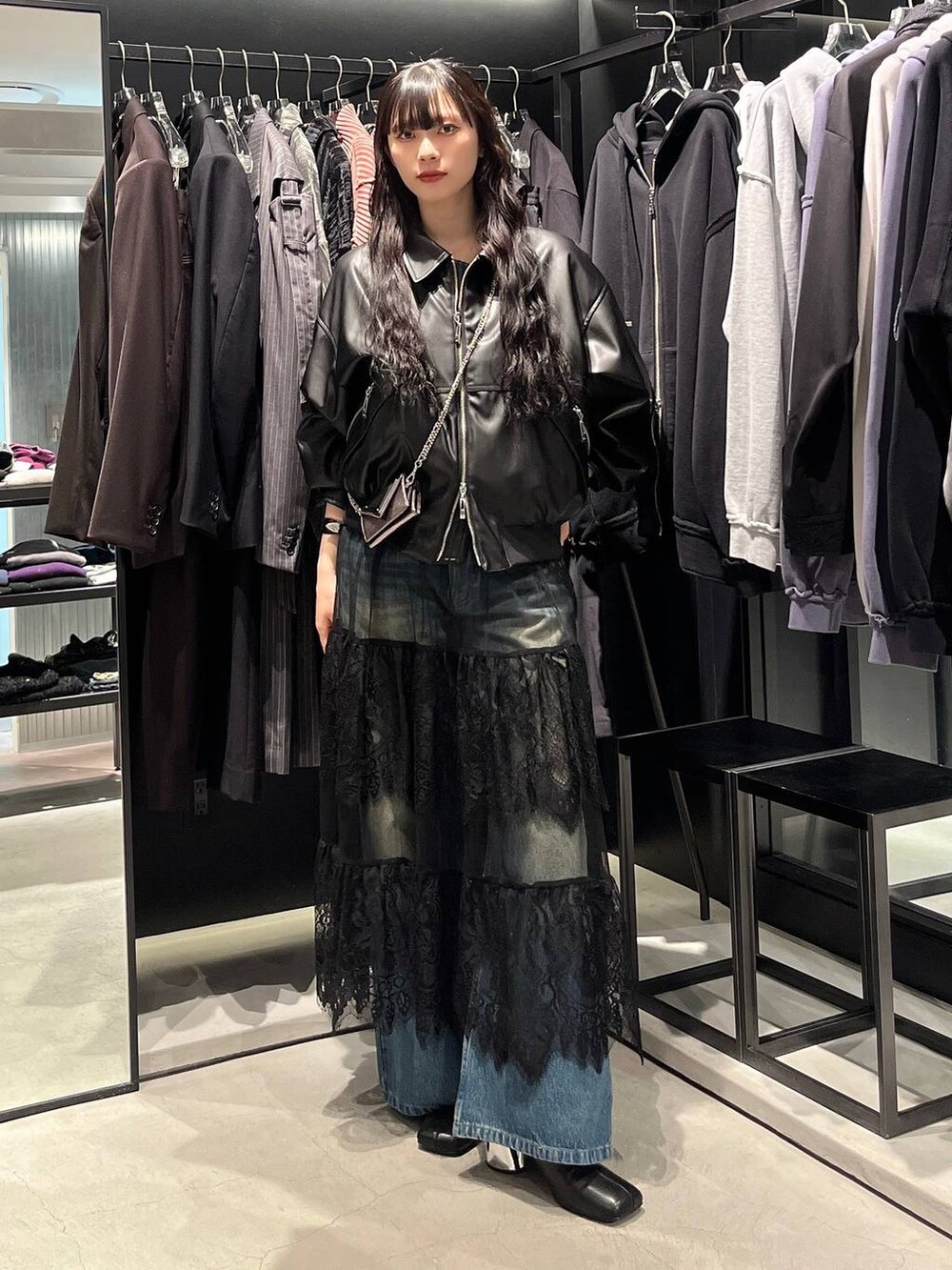 ブルー系のデニムパンツ、ブラック系のブーツ、ブラック系のブルゾンを着用したレディースの秋コーディネートの5枚目の写真