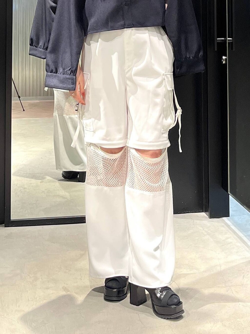 ブラック系のブーツ、ブルー系のシャツ/ブラウス、ホワイト系のカーゴパンツを着用したレディースの春コーディネートの4枚目の写真