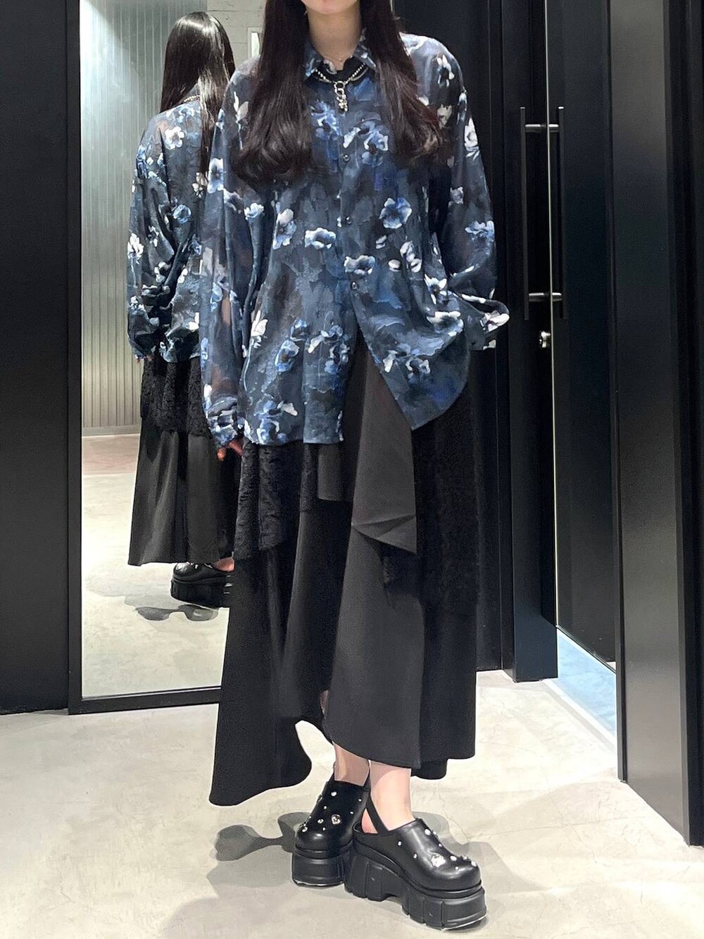 ブラック系のスカート、ブラック系のサンダル、シルバー系のネックレスを着用したレディースの春コーディネートの3枚目の写真