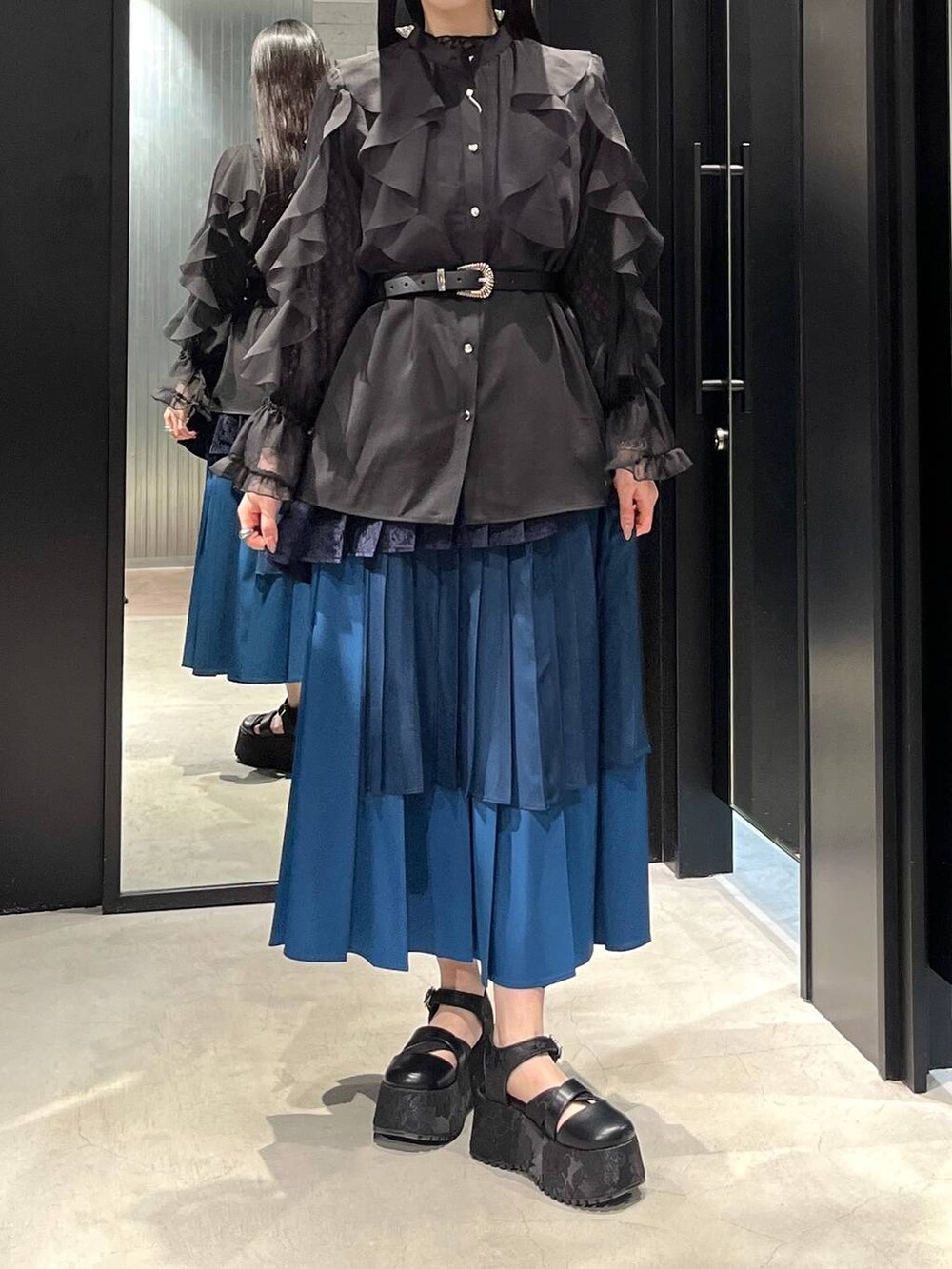 ブラック系のサンダル、ブラック系のシャツ/ブラウス、ブルー系のスカートを着用したレディースの春コーディネートの2枚目の写真