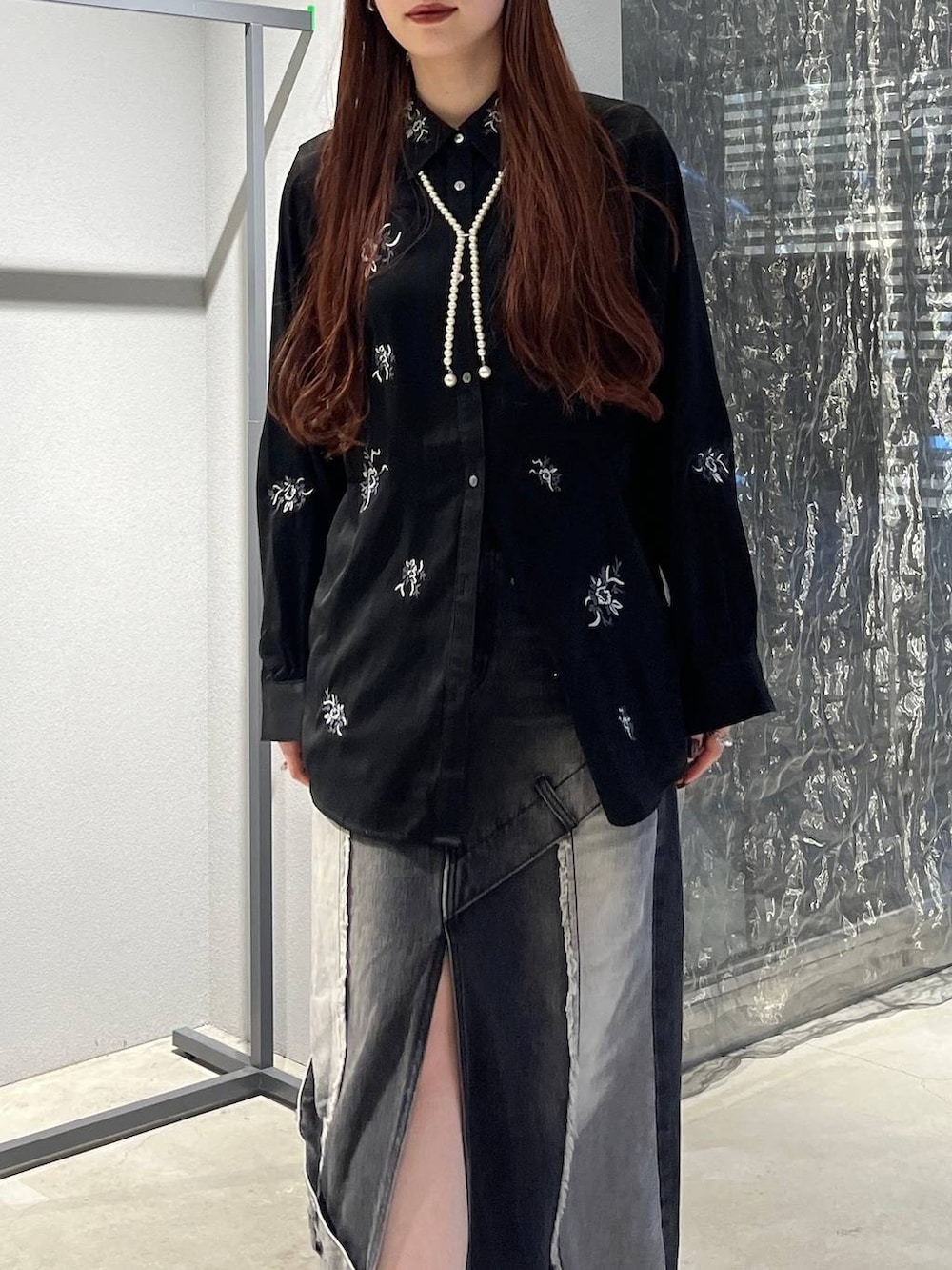 ブラック系のデニムスカート、ブラック系のシャツ/ブラウス、ブラック系のブーツを着用したレディースの秋コーディネートの6枚目の写真