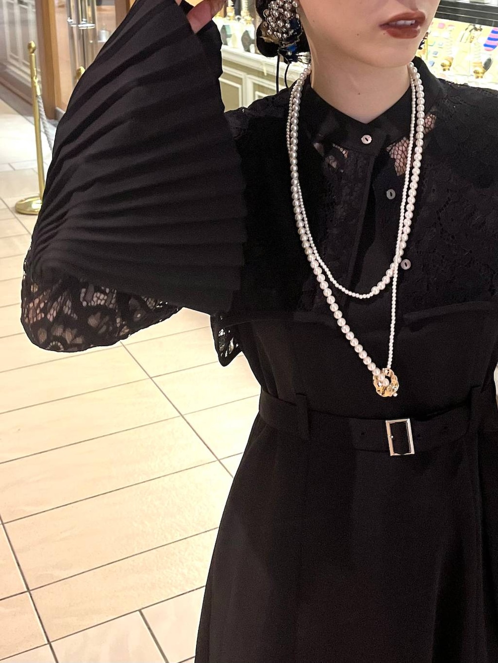 ブラック系のドレス、ゴールド系のネックレスを着用したレディースの夏コーディネートの6枚目の写真