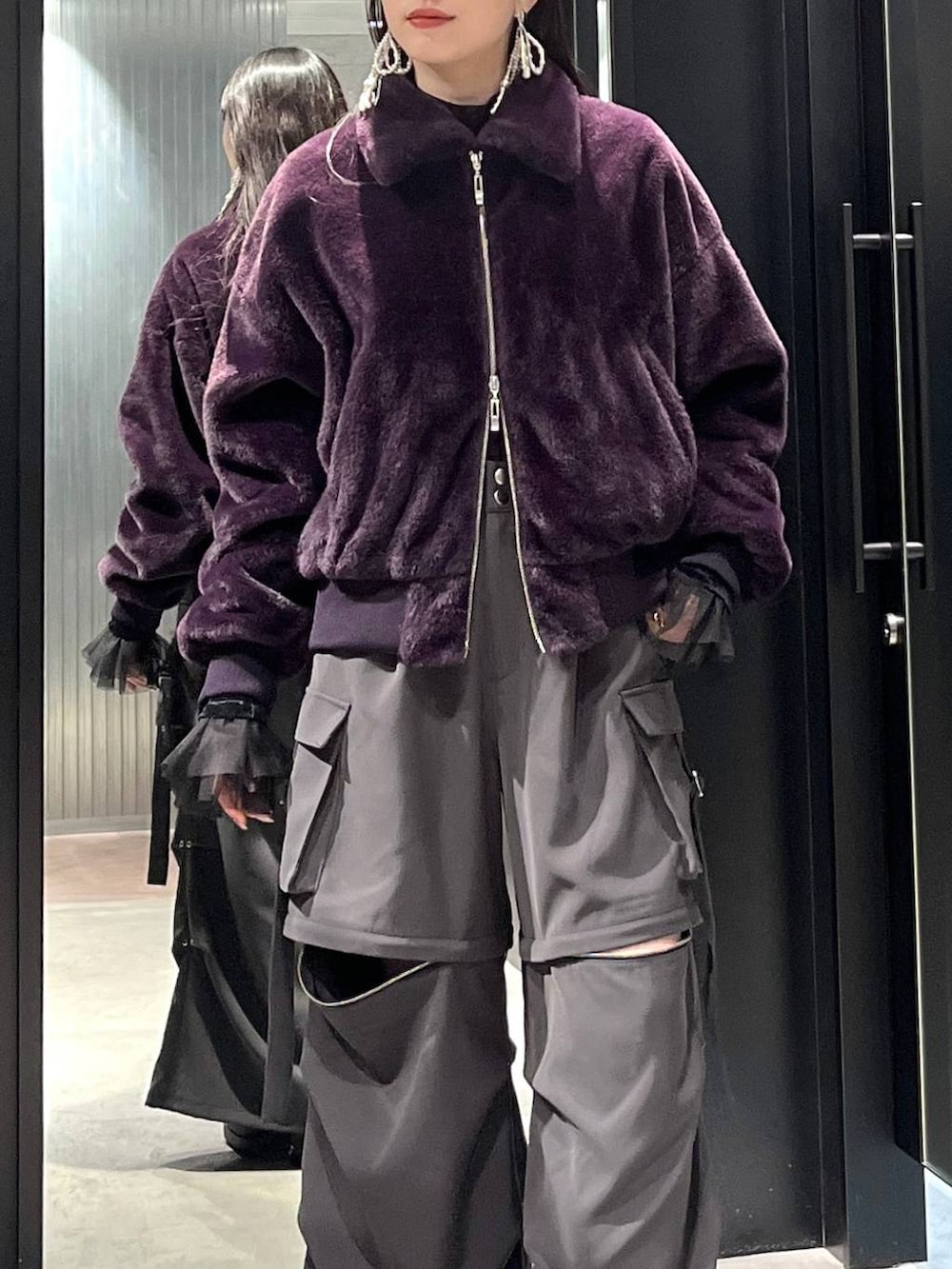 グレー系のカーゴパンツ、ブラック系のブーツ、ブラック系のTシャツ/カットソーを着用したレディースの冬コーディネートの3枚目の写真