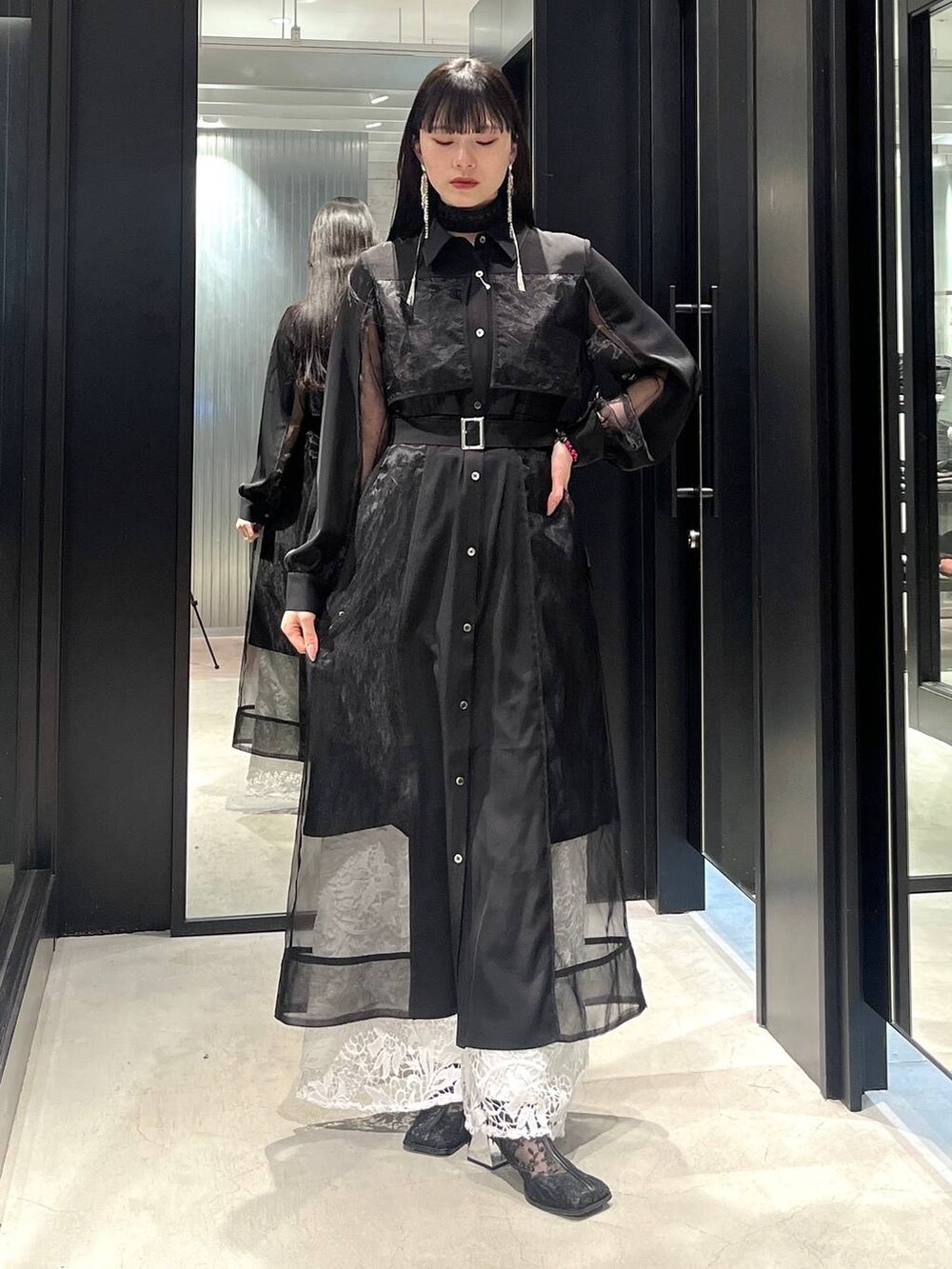 ブラック系のブーツ、ホワイト系のその他パンツ、ブラック系のワンピースを着用したレディースの冬コーディネートの2枚目の写真