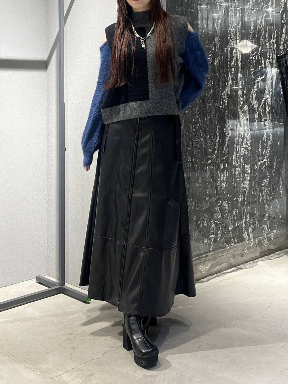 ブラック系のブーツ、ブラック系のニット/セーター、ブラック系のスカートを着用したレディースの秋コーディネートの5枚目の写真