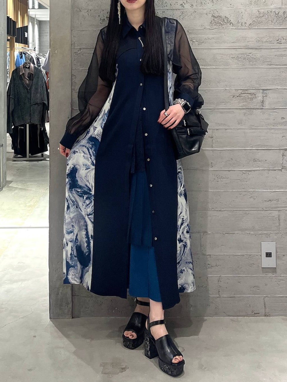 ブルー系のワンピース、ブルー系のスカート、ブラック系のショルダーバッグを着用したレディースの春コーディネートの2枚目の写真