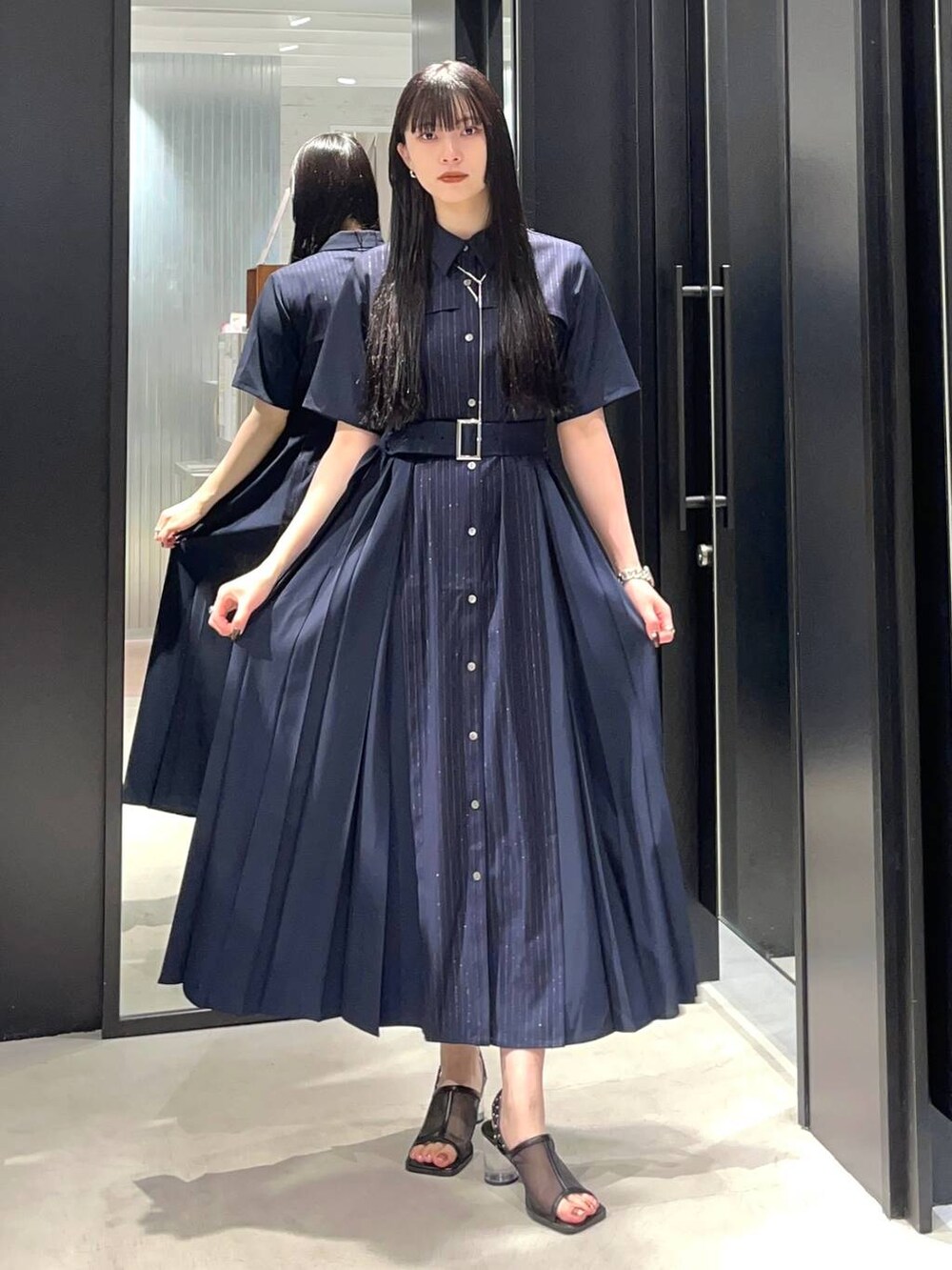 ブラック系のサンダル、ブルー系のワンピース、シルバー系のネックレスを着用したレディースの春コーディネートの2枚目の写真