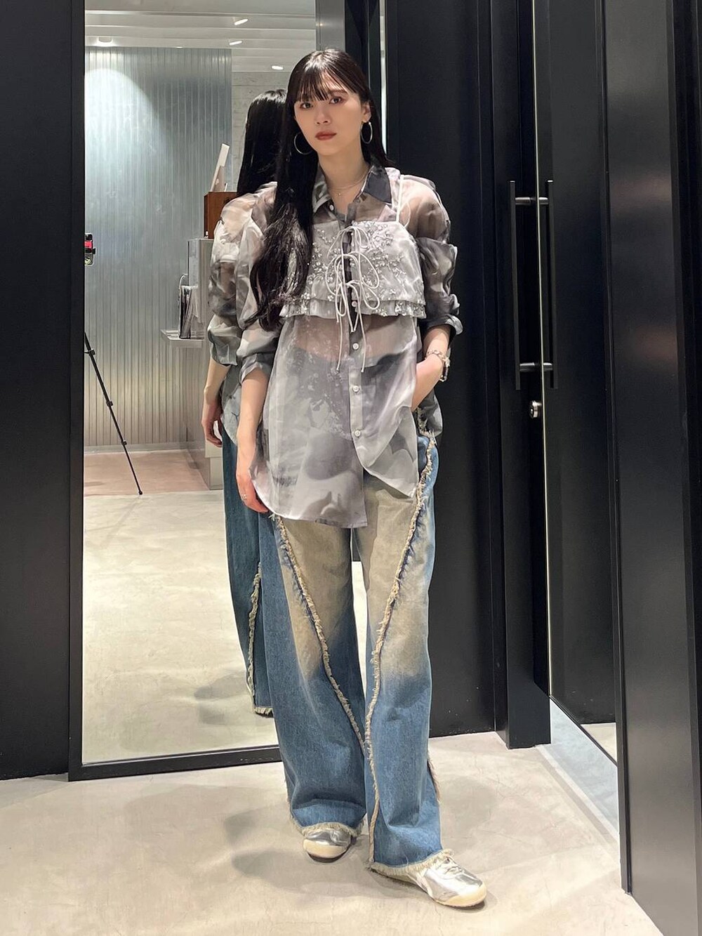 ブルー系のデニムパンツ、シルバー系のベスト、ホワイト系のシャツ/ブラウスを着用したレディースの夏コーディネートの2枚目の写真