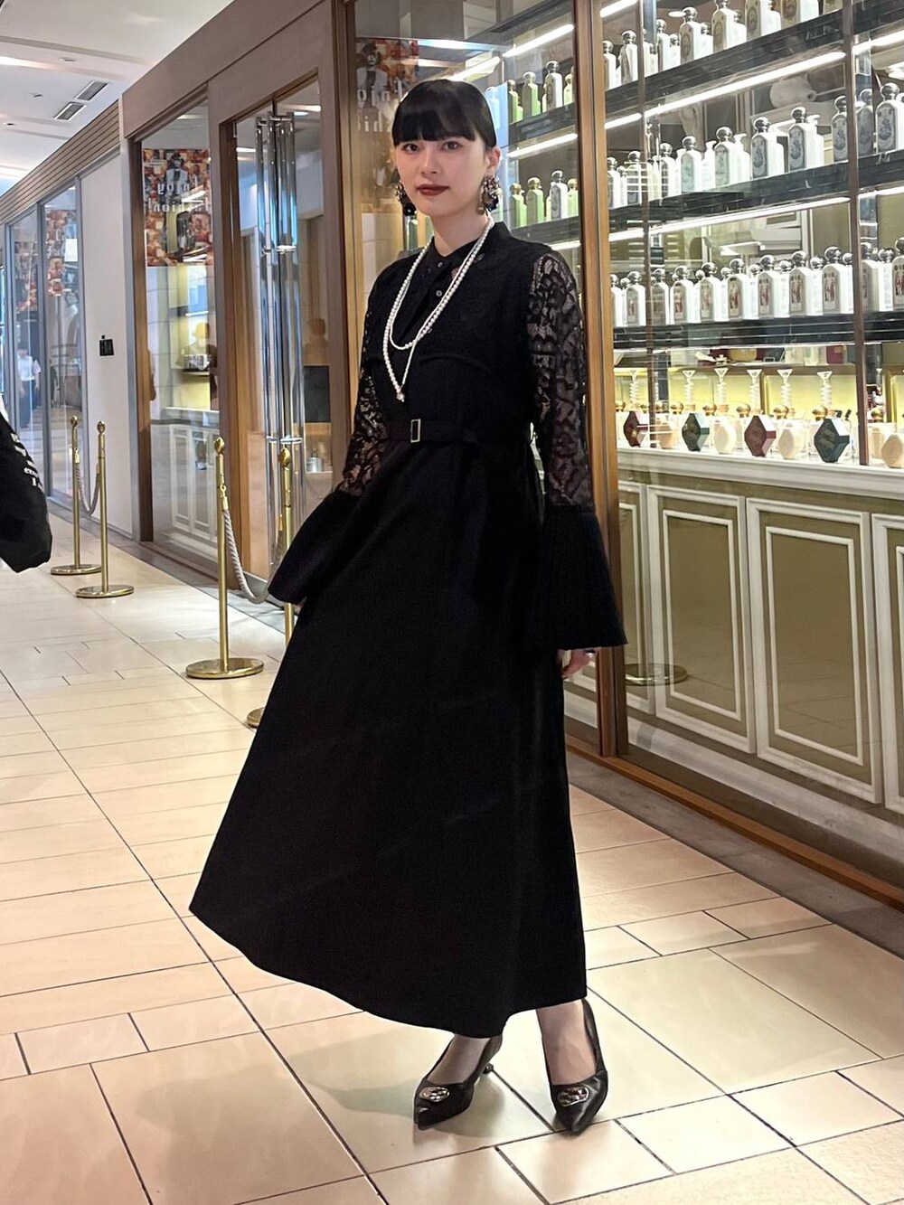 ブラック系のドレス、ゴールド系のネックレスを着用したレディースの夏コーディネートの3枚目の写真