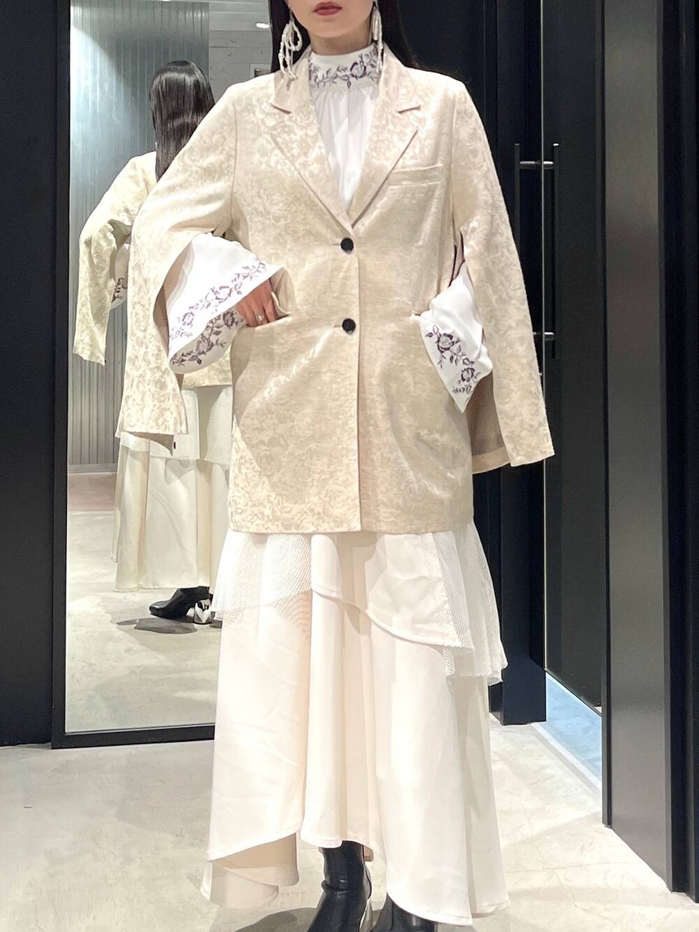 ブラック系のブーツ、ホワイト系のシャツ/ブラウス、ホワイト系のテーラードジャケットを着用したレディースの冬コーディネートの3枚目の写真