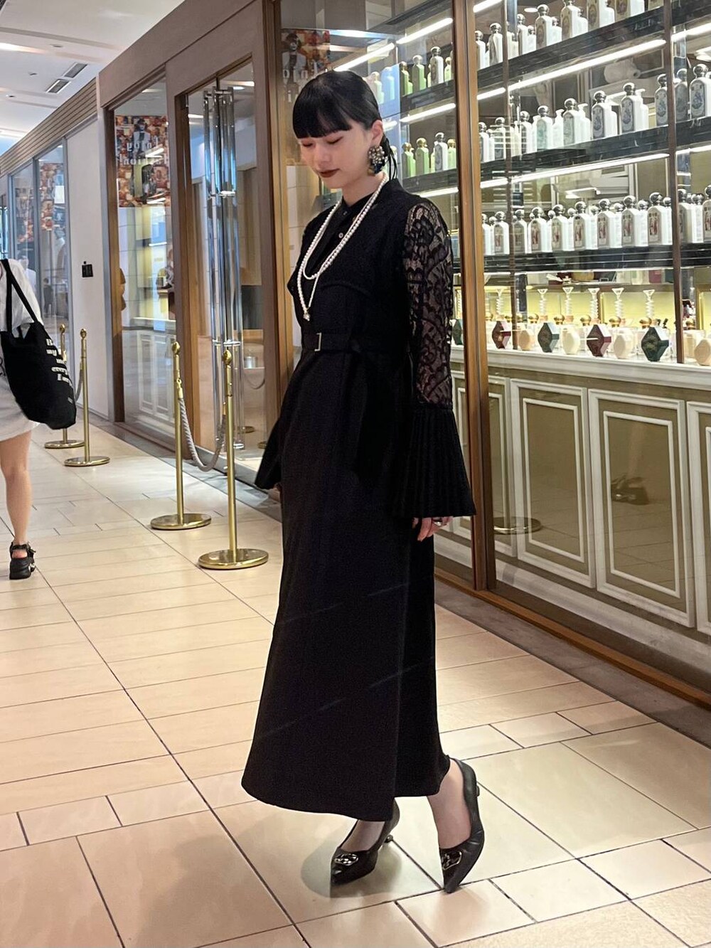 ブラック系のドレス、ゴールド系のネックレスを着用したレディースの夏コーディネートの4枚目の写真