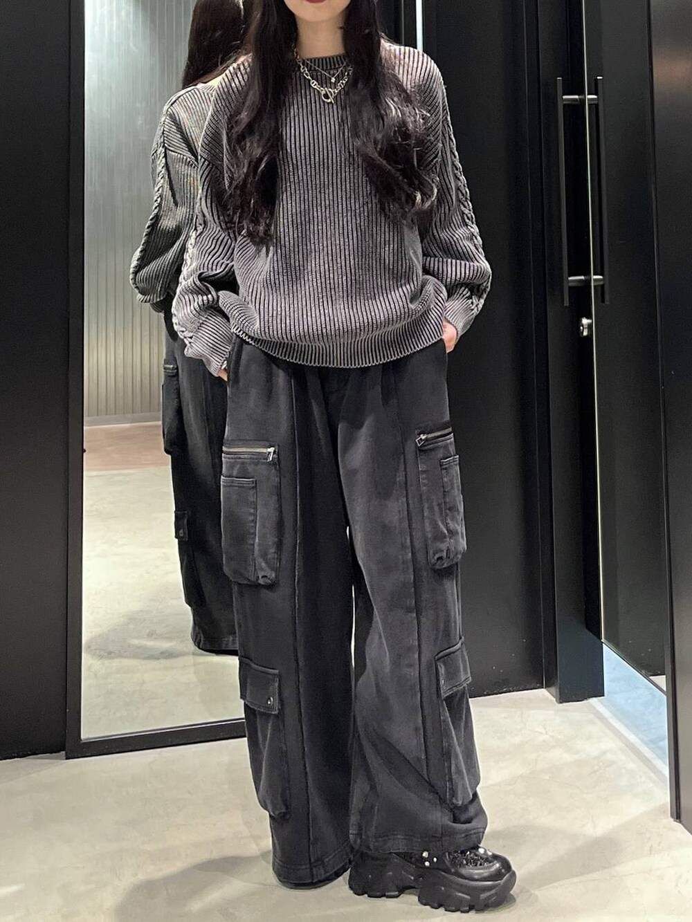 ブラック系のスニーカー、ブラック系のニット/セーターを着用したレディースの秋コーディネートの2枚目の写真