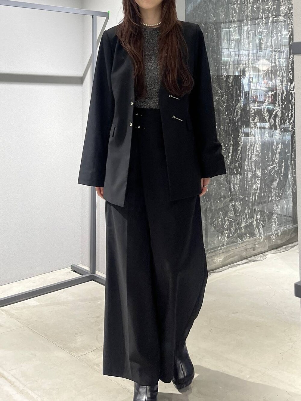 グレー系のブーツ、ブラック系のノーカラージャケット、ブラック系のスラックスを着用したレディースの秋コーディネートの4枚目の写真