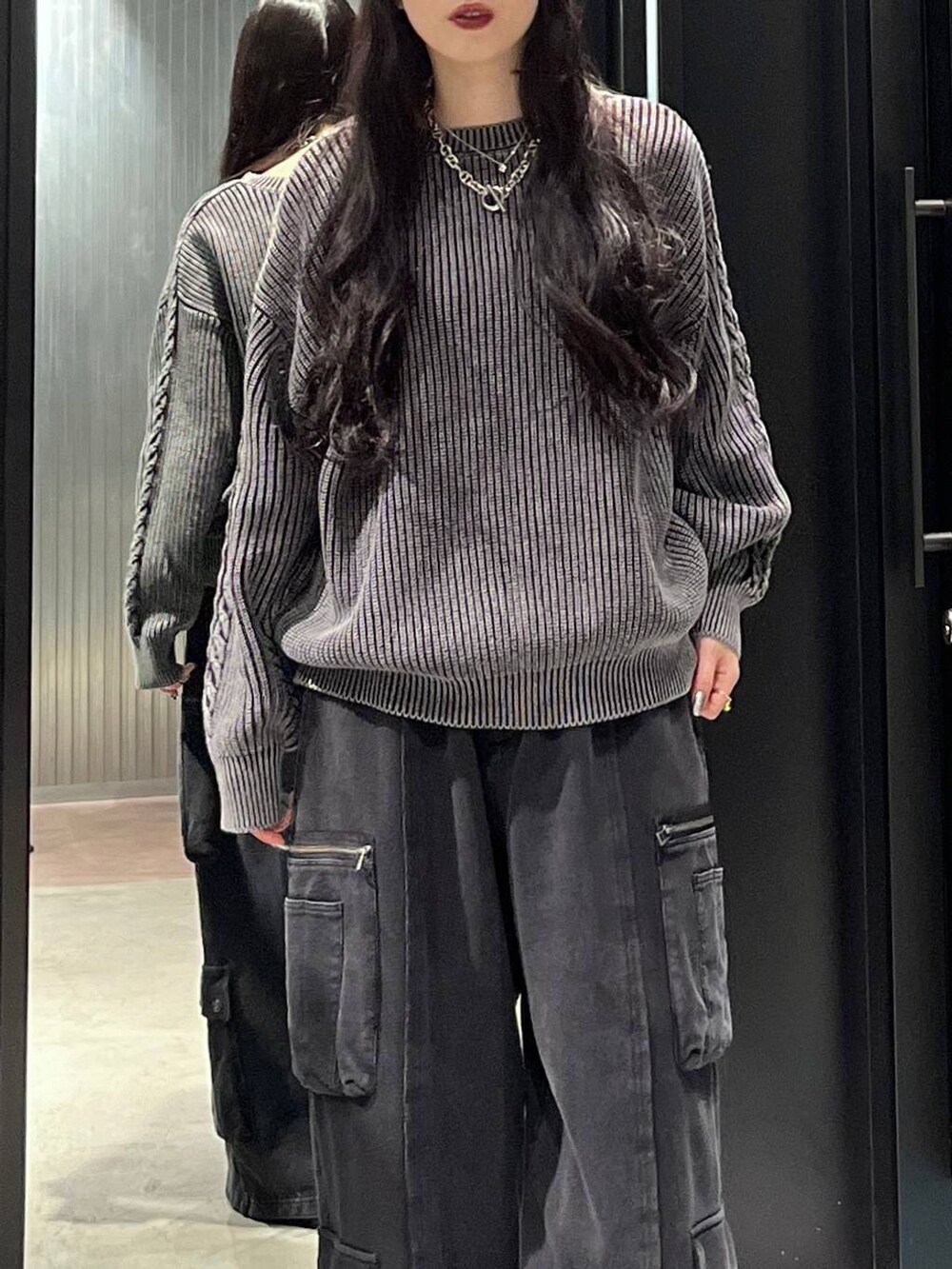 ブラック系のスニーカー、ブラック系のニット/セーターを着用したレディースの秋コーディネートの3枚目の写真