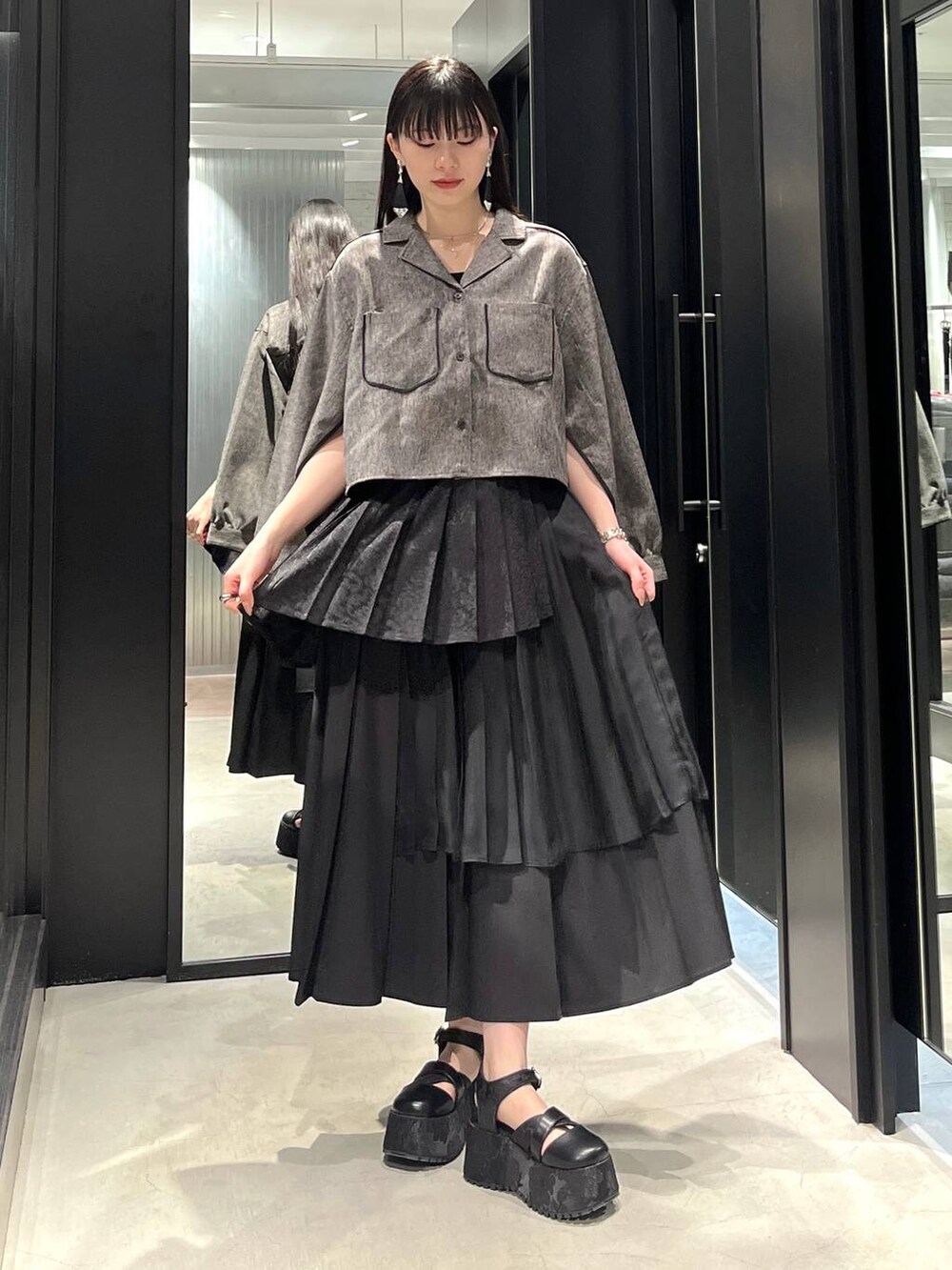 ブラック系のサンダル、ブラック系のスカート、ブラック系のシャツ/ブラウスを着用したレディースの春コーディネートの2枚目の写真