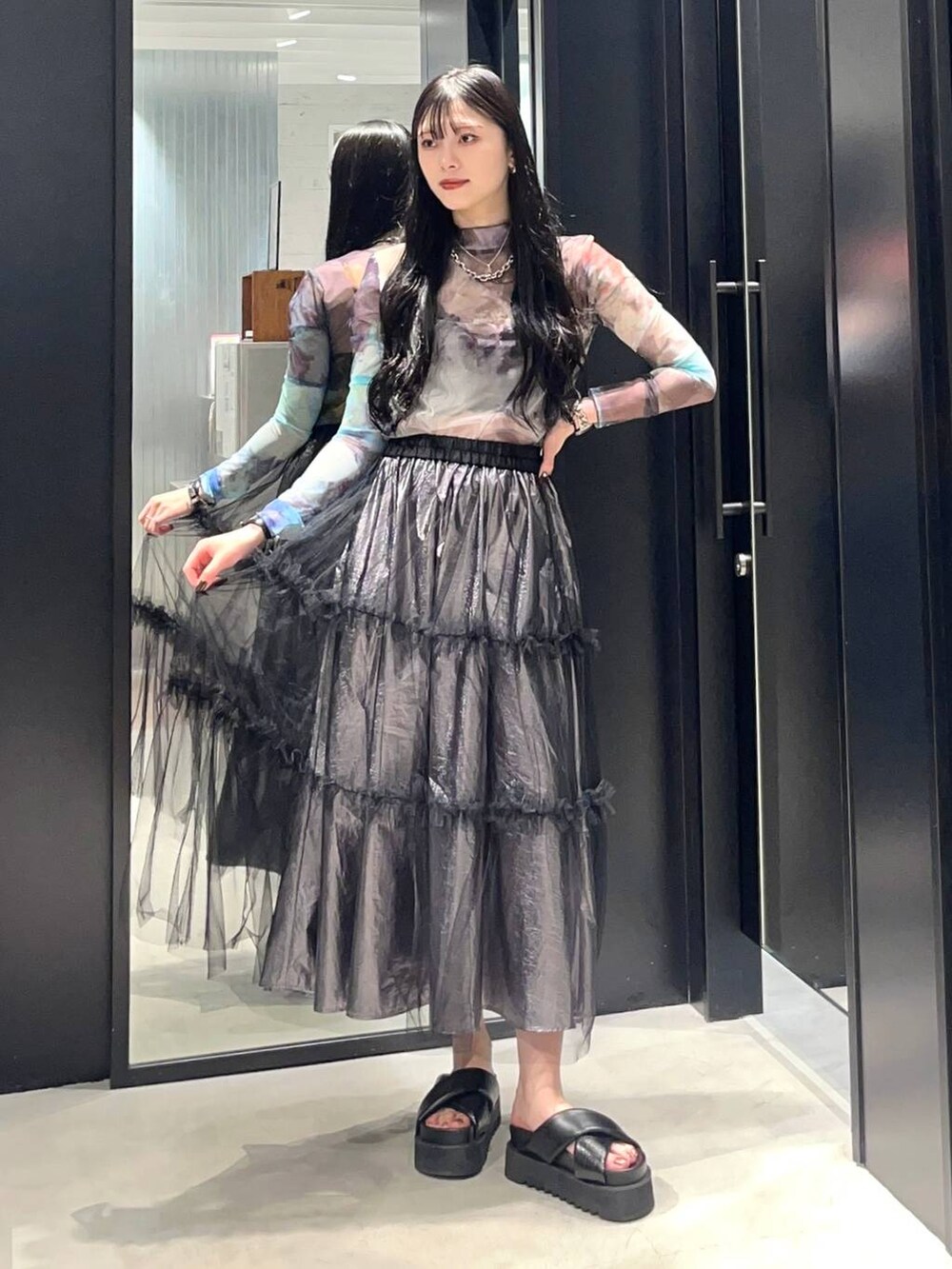 ブラック系のサンダル、シルバー系のスカート、その他のTシャツ/カットソーを着用したレディースの春コーディネートの2枚目の写真