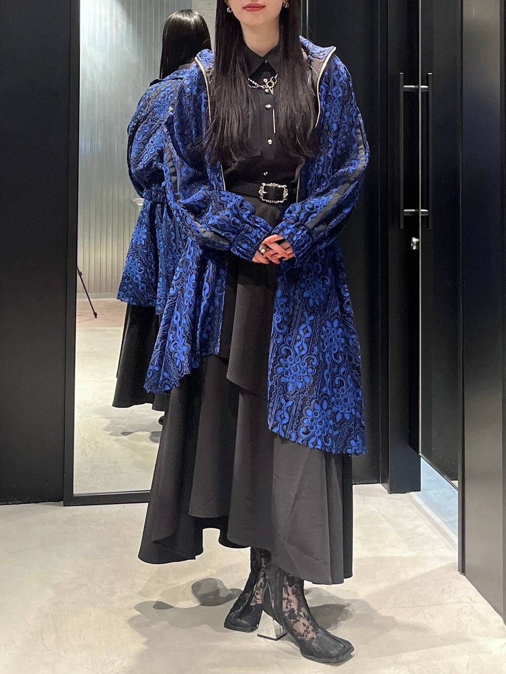 ブルー系のブルゾン、ブラック系のブーツ、ブルー系のスカートを着用したレディースの春コーディネートの3枚目の写真