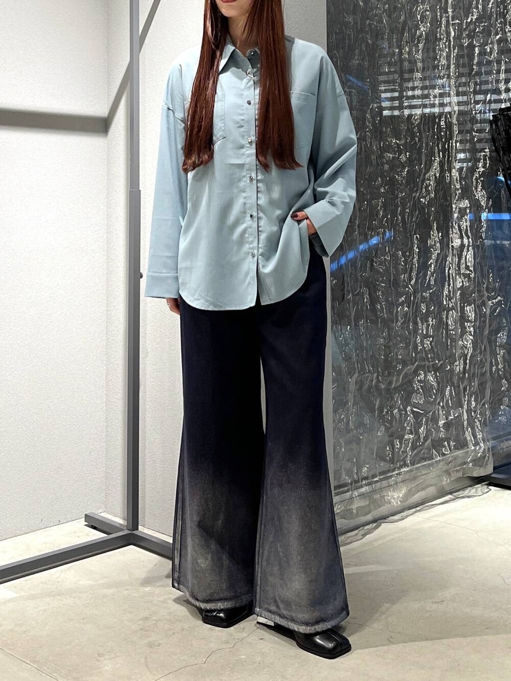 ブラック系のブーツ、ブルー系のデニムパンツを着用したレディースの夏コーディネートの3枚目の写真