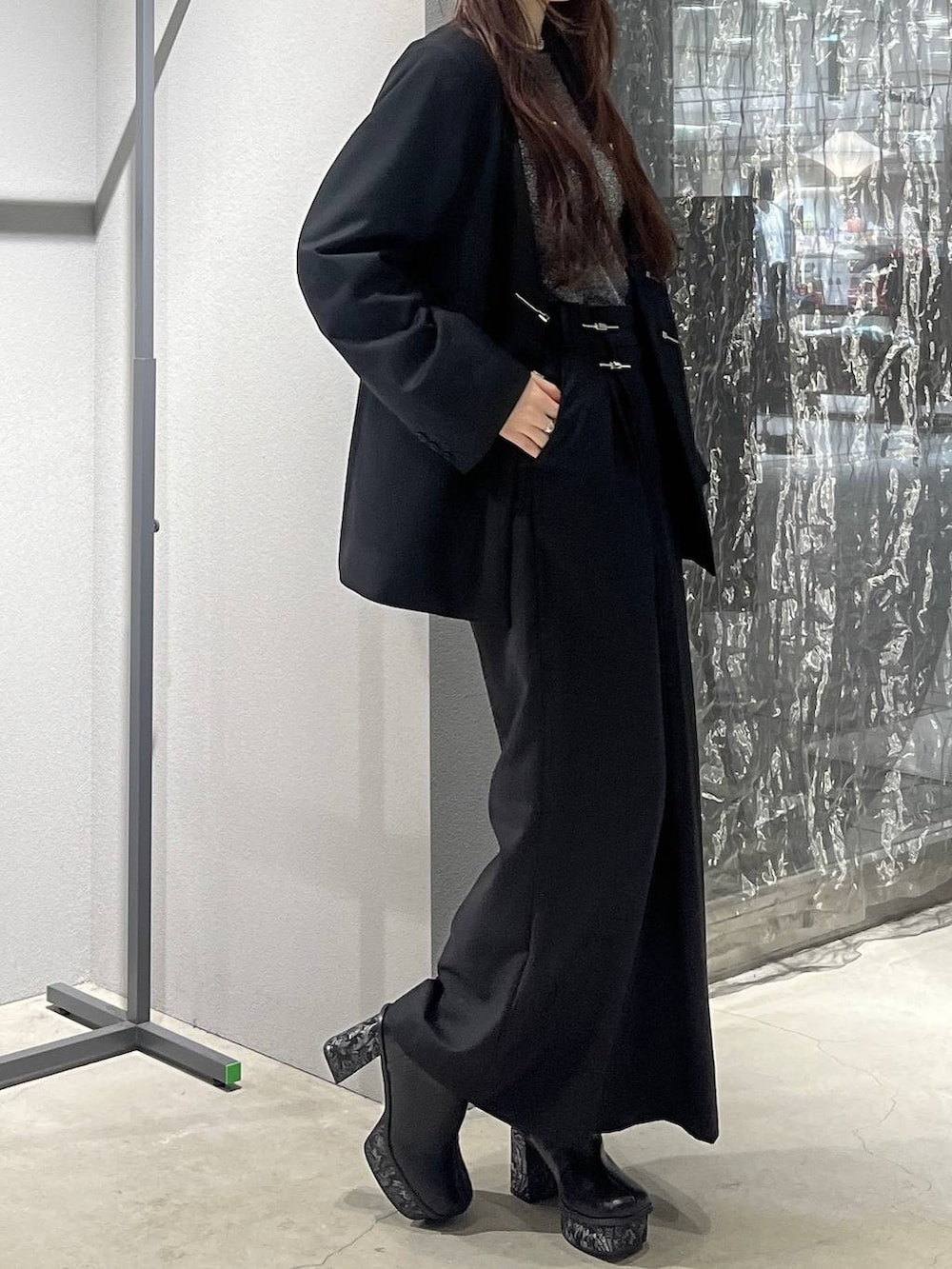 グレー系のブーツ、ブラック系のノーカラージャケット、ブラック系のスラックスを着用したレディースの秋コーディネートの3枚目の写真