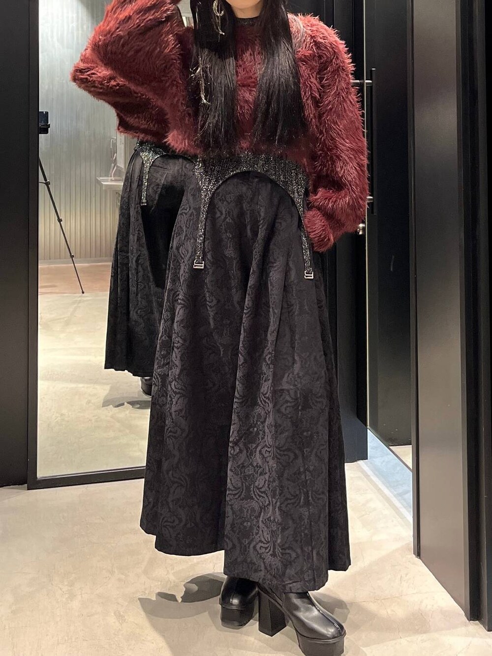 レッド系のニット/セーター、ブラック系のブーツ、ブラック系のニット/セーターを着用したレディースの秋コーディネートの5枚目の写真