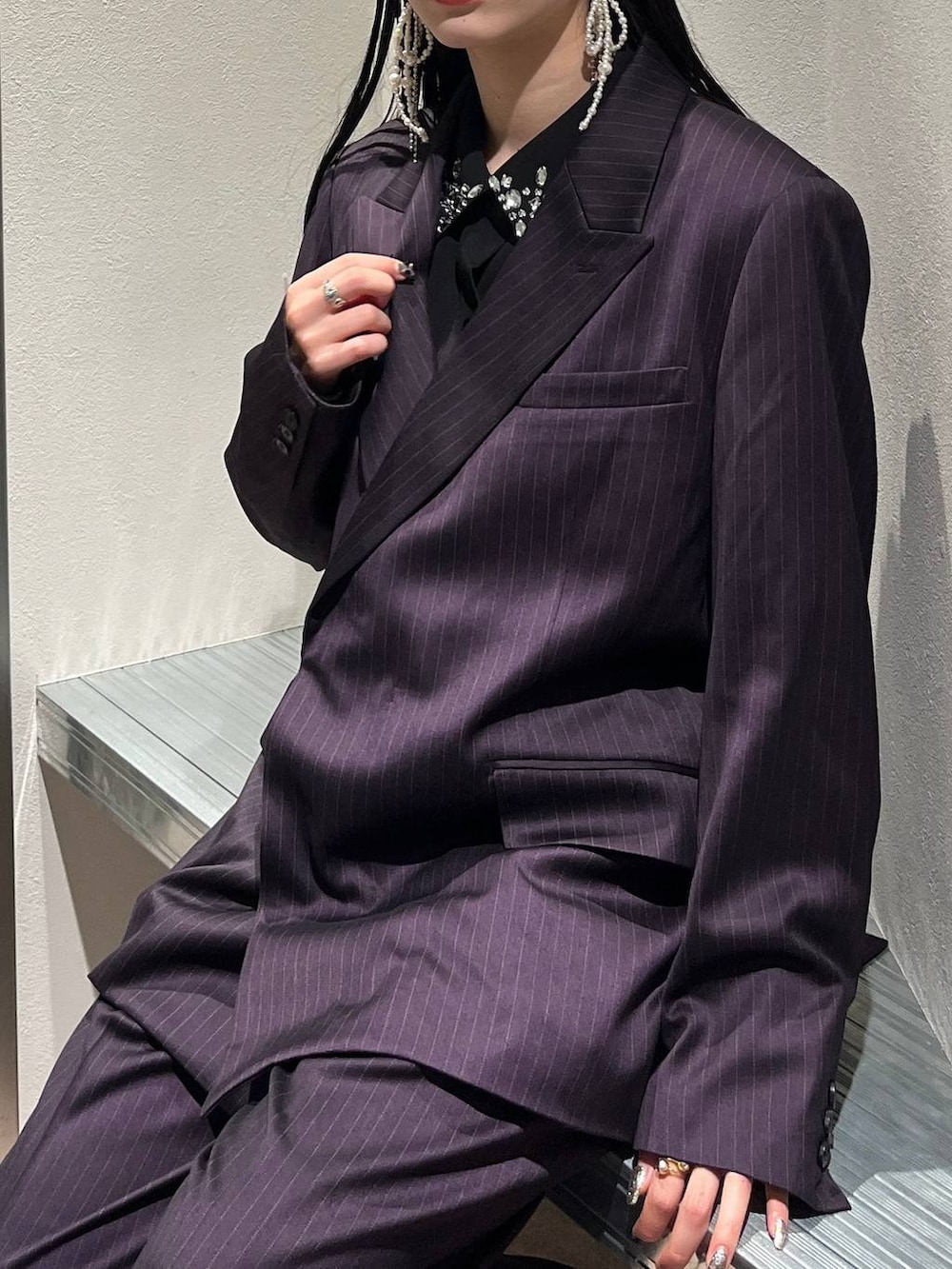 シルバー系のブーツ、ブラック系のシャツ/ブラウス、パープル系のスラックスを着用したレディースの秋コーディネートの3枚目の写真