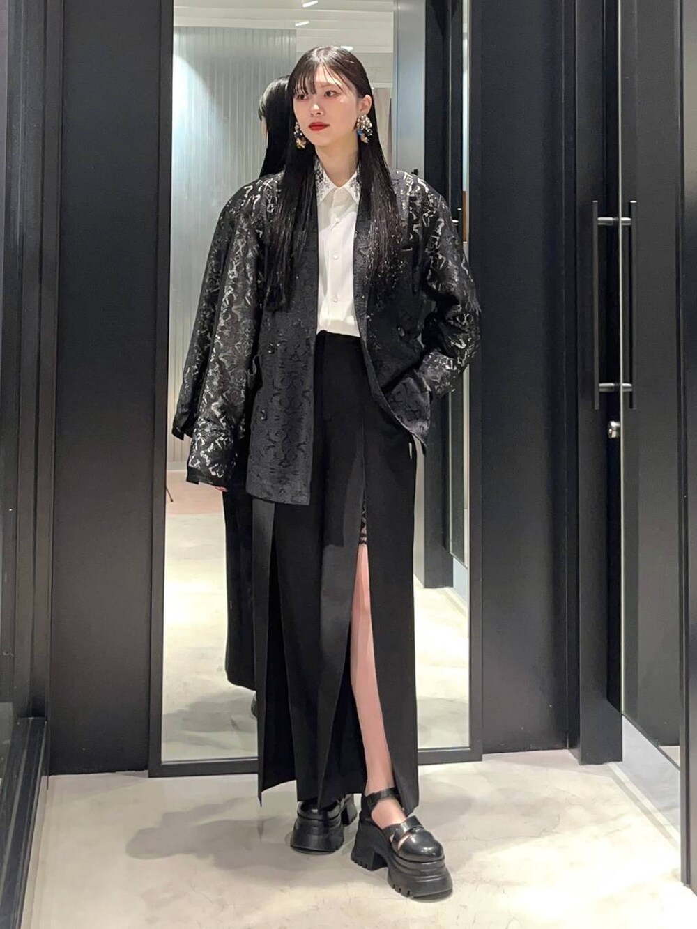 ホワイト系のシャツ/ブラウス、ブラック系のテーラードジャケット、ブラック系のサンダルを着用したレディースの春コーディネートの2枚目の写真