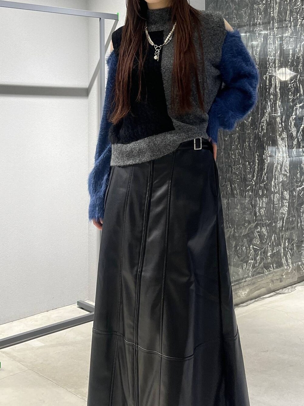 ブラック系のブーツ、ブラック系のニット/セーター、ブラック系のスカートを着用したレディースの秋コーディネートの6枚目の写真