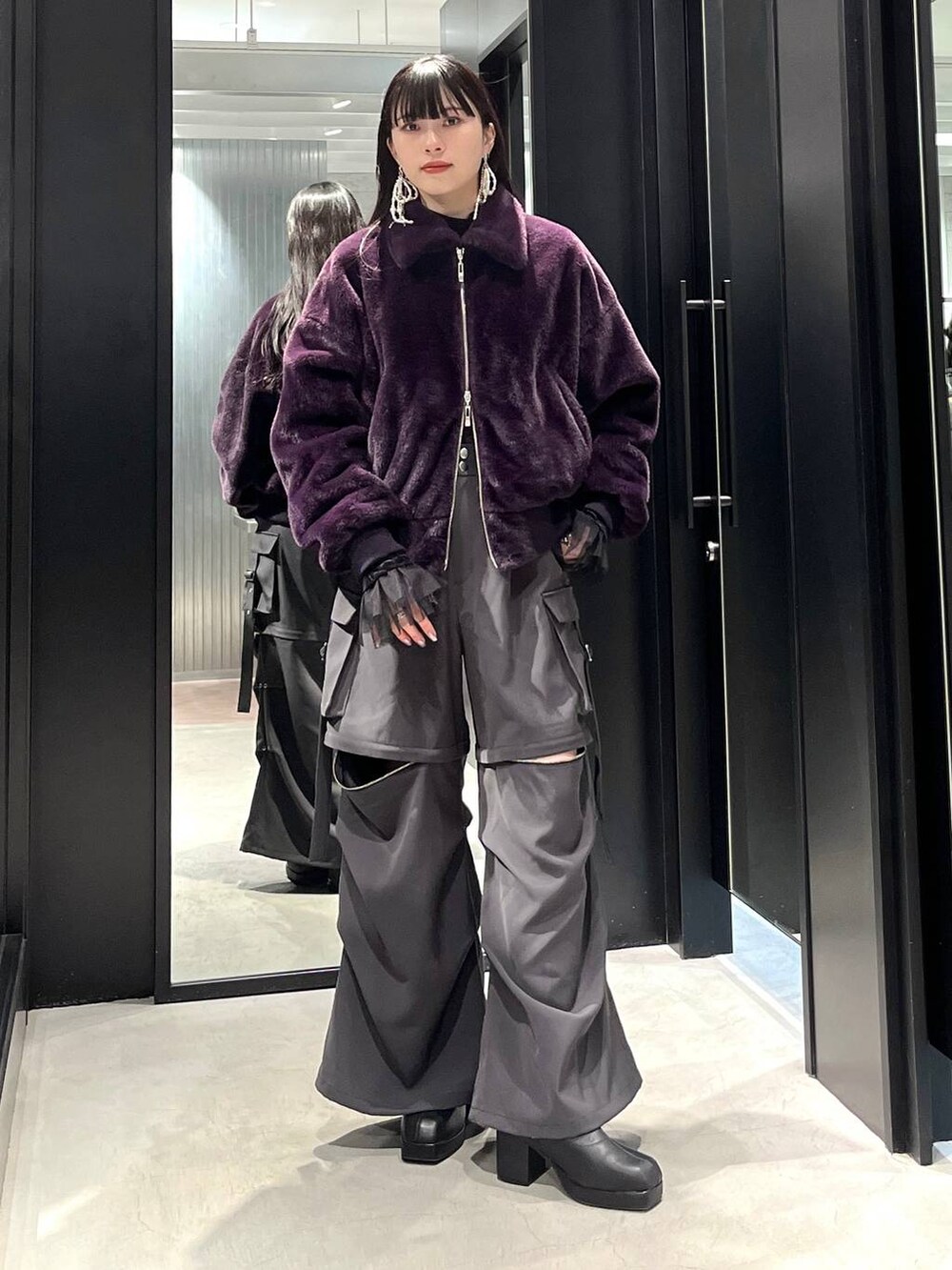 グレー系のカーゴパンツ、ブラック系のブーツ、ブラック系のTシャツ/カットソーを着用したレディースの冬コーディネートの5枚目の写真