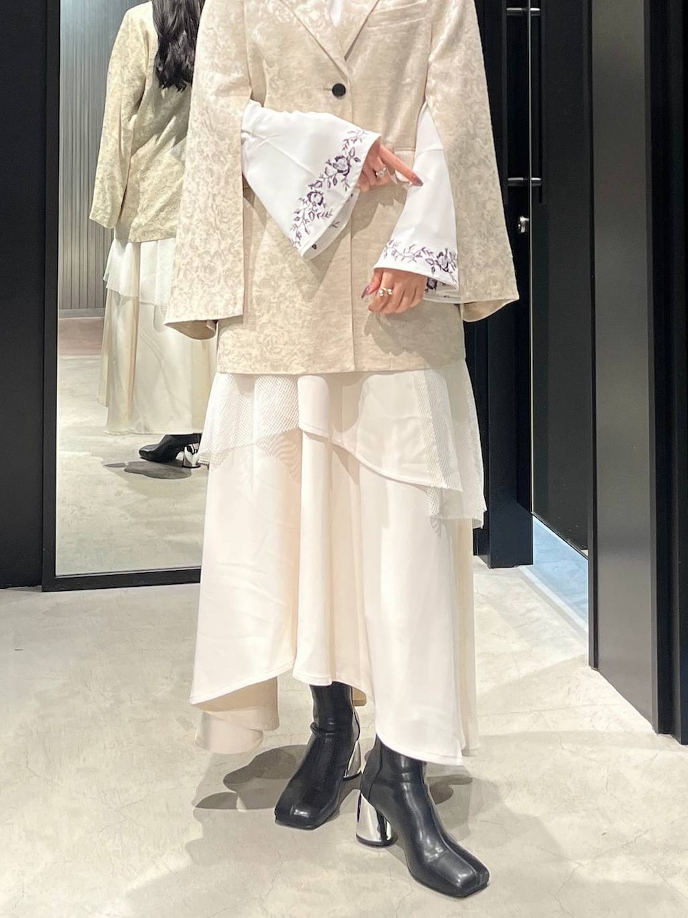 ブラック系のブーツ、ホワイト系のシャツ/ブラウス、ホワイト系のテーラードジャケットを着用したレディースの冬コーディネートの4枚目の写真