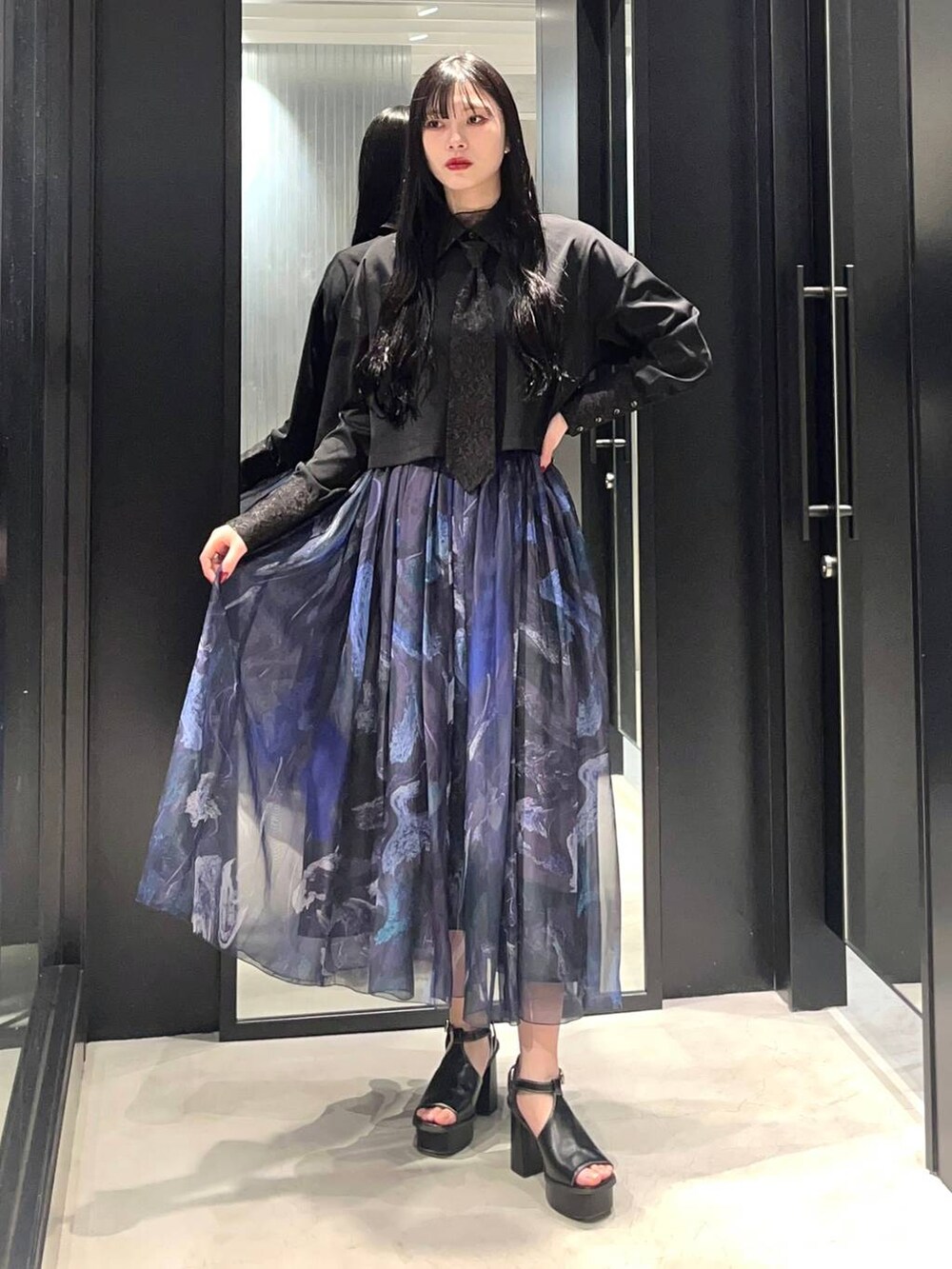 ブラック系のサンダル、ブラック系のシャツ/ブラウス、パープル系のスカートを着用したレディースの春コーディネートの2枚目の写真