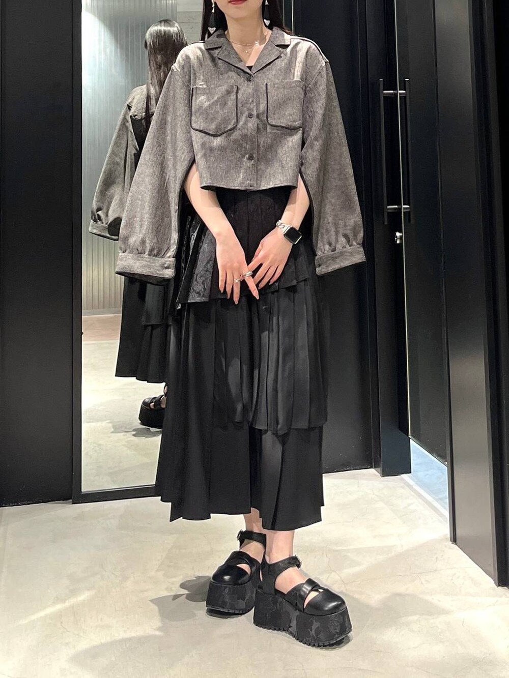 ブラック系のサンダル、ブラック系のスカート、ブラック系のシャツ/ブラウスを着用したレディースの春コーディネートの4枚目の写真