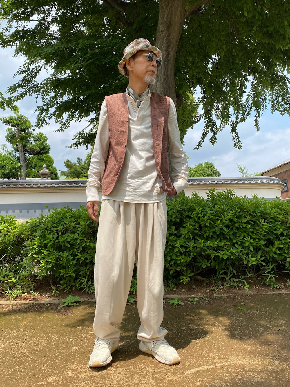 ホワイト系のスウェットパンツ、ホワイト系のスニーカー、ブラウン系のベストを着用したメンズの夏コーディネートの5枚目の写真