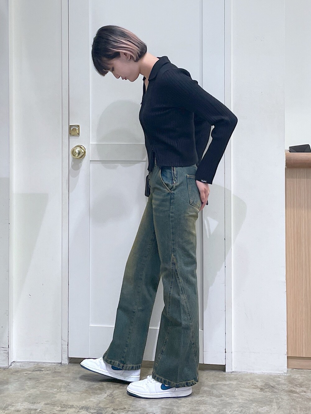 ブラック系のニット/セーター、ブルー系のデニムパンツ、ゴールド系のコインケースを着用したメンズの秋コーディネートの2枚目の写真