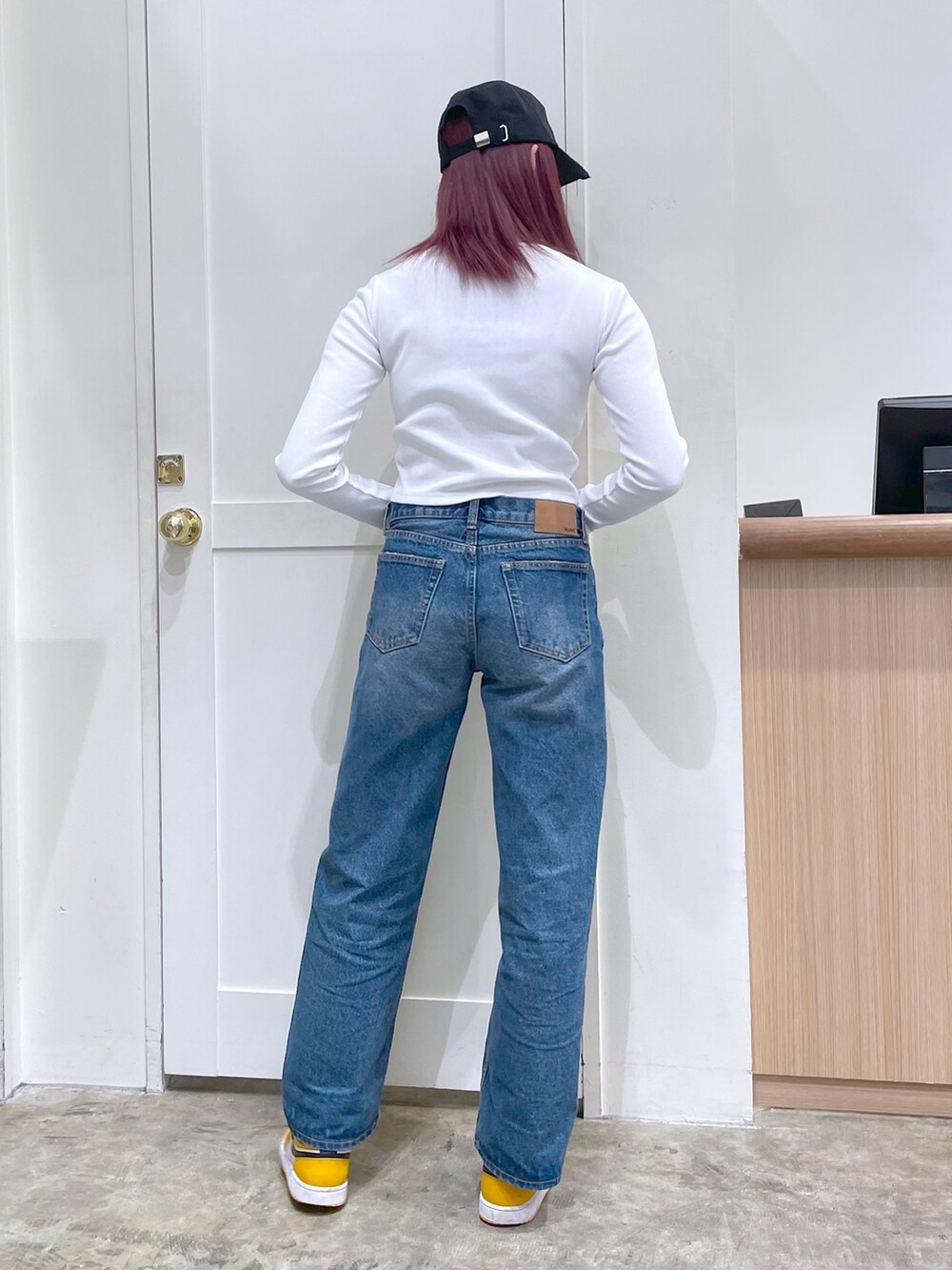 ブルー系のデニムパンツ、ホワイト系のカーディガン/ボレロ、ブラック系のキャップを着用したメンズの春コーディネートの3枚目の写真