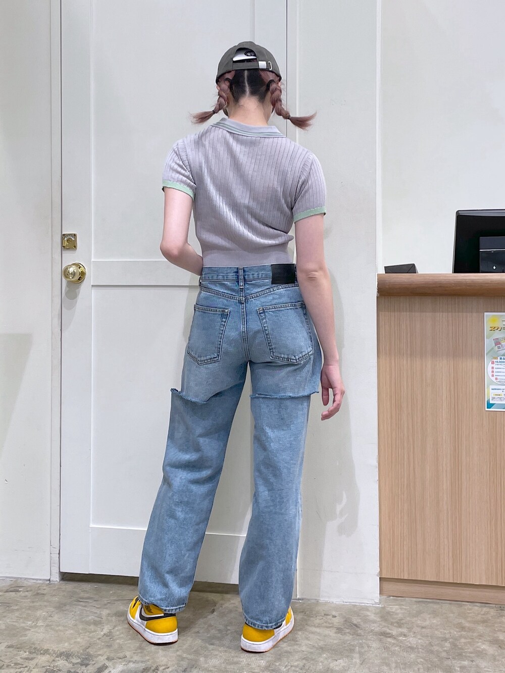 グレー系のポロシャツ、ブルー系のデニムパンツ、グリーン系のキャップを着用したメンズの春コーディネートの3枚目の写真