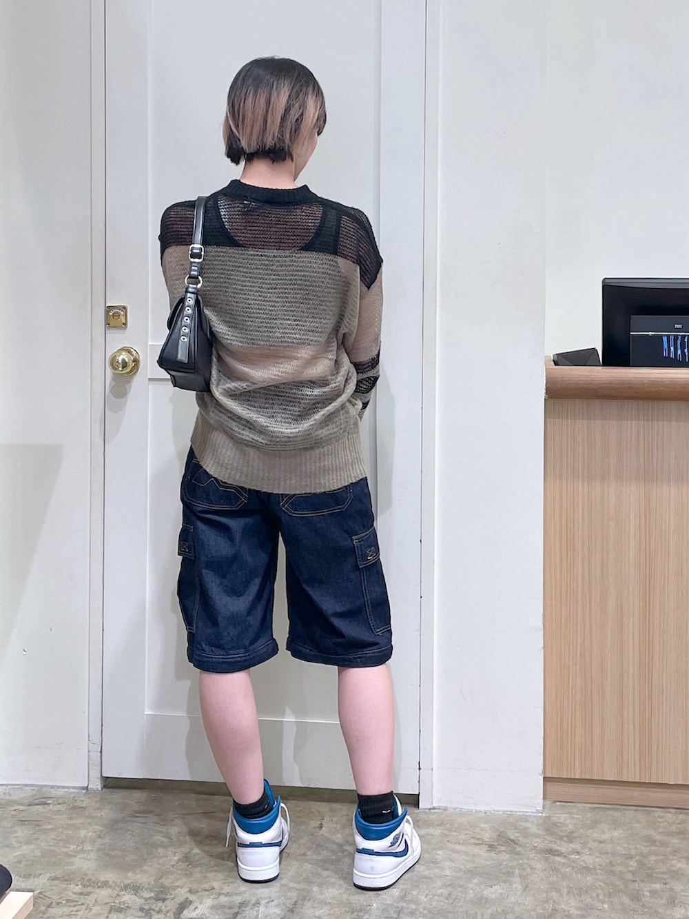 グリーン系のニット/セーター、グリーン系のタンクトップ、ブラック系のショルダーバッグを着用したメンズの秋コーディネートの3枚目の写真